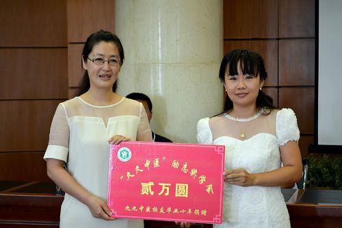 招生就业处处长陈冬梅(左)代表完美(中国)一站式服务平台接受“久久中医”励志奖学金